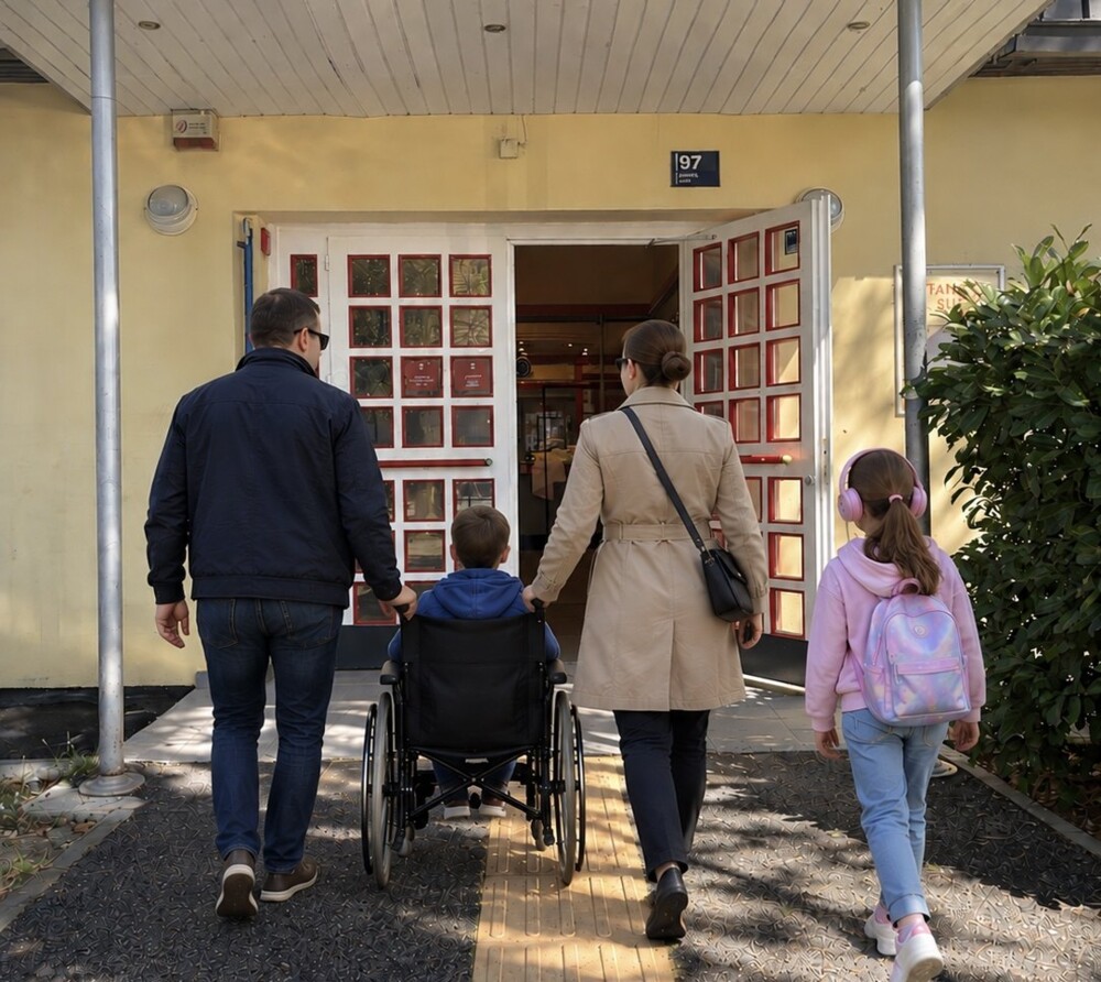 Obitelj s djetetom u invalidskim kolicima ulazi u kazalište kroz široka dvokrilna vrata