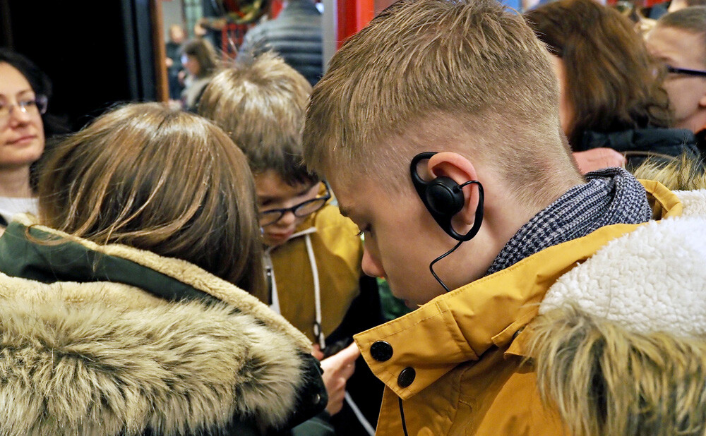 Dječak sa slušalicama za audiodeskripciju u predvorju kazališta